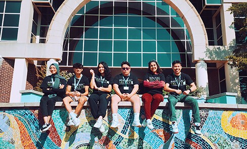 students sitting on a wall in front of RVCC