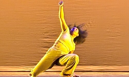 dancer in yellow outfit kneeling on floor