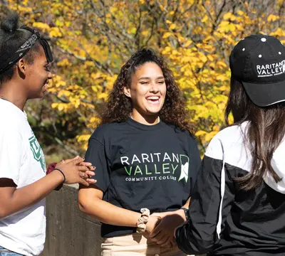 fall leaves three students outside