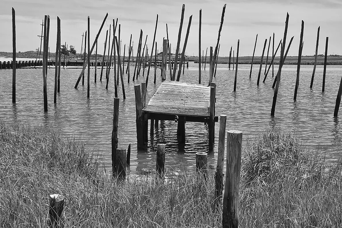 black and white photo of dock in water
