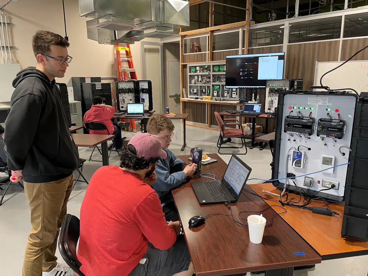 CEM-Tech students looking at laptop and machines