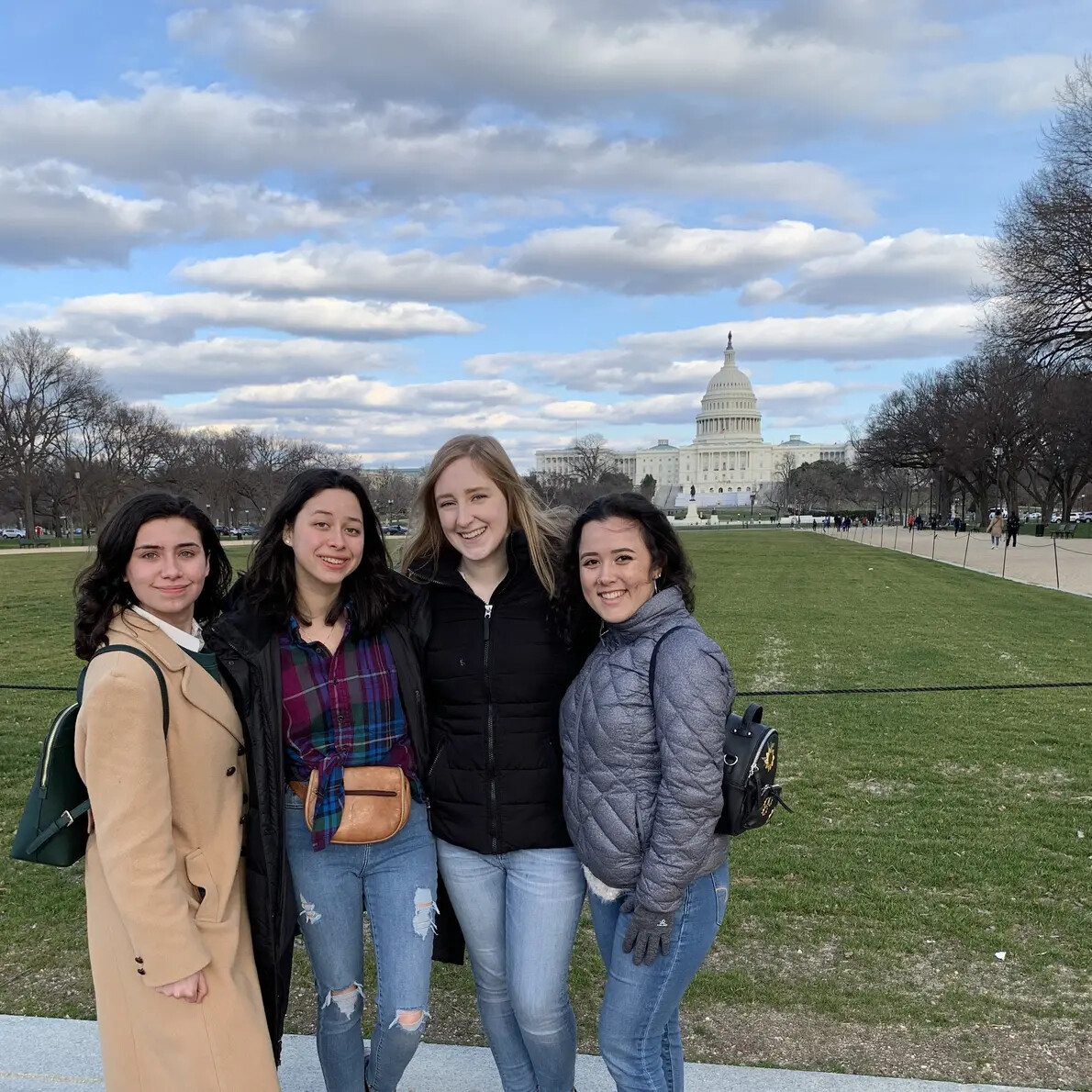 four female students with capitol in distance behind them
