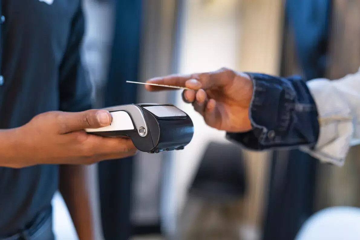 hands of clerk and customer paying by credit card