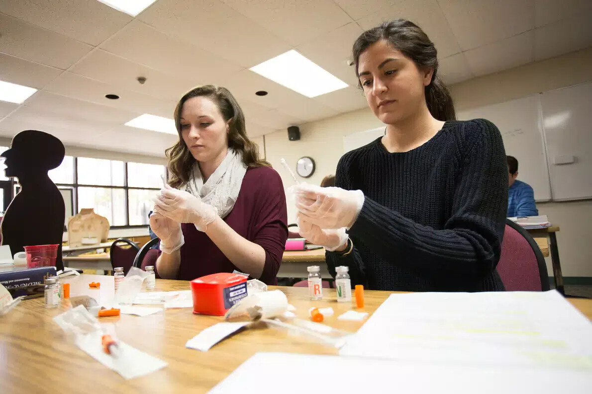 2 female nursing students wearing rubber gloves