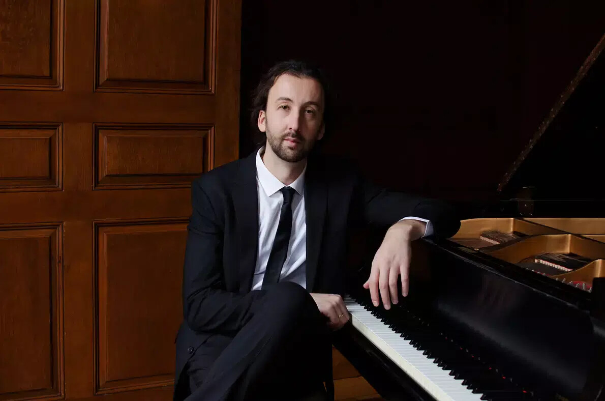 man with beard wearing tie at piano