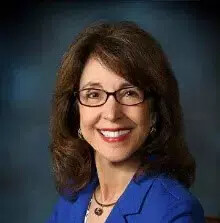 ellen kennedy wearing glasses and blue blazer