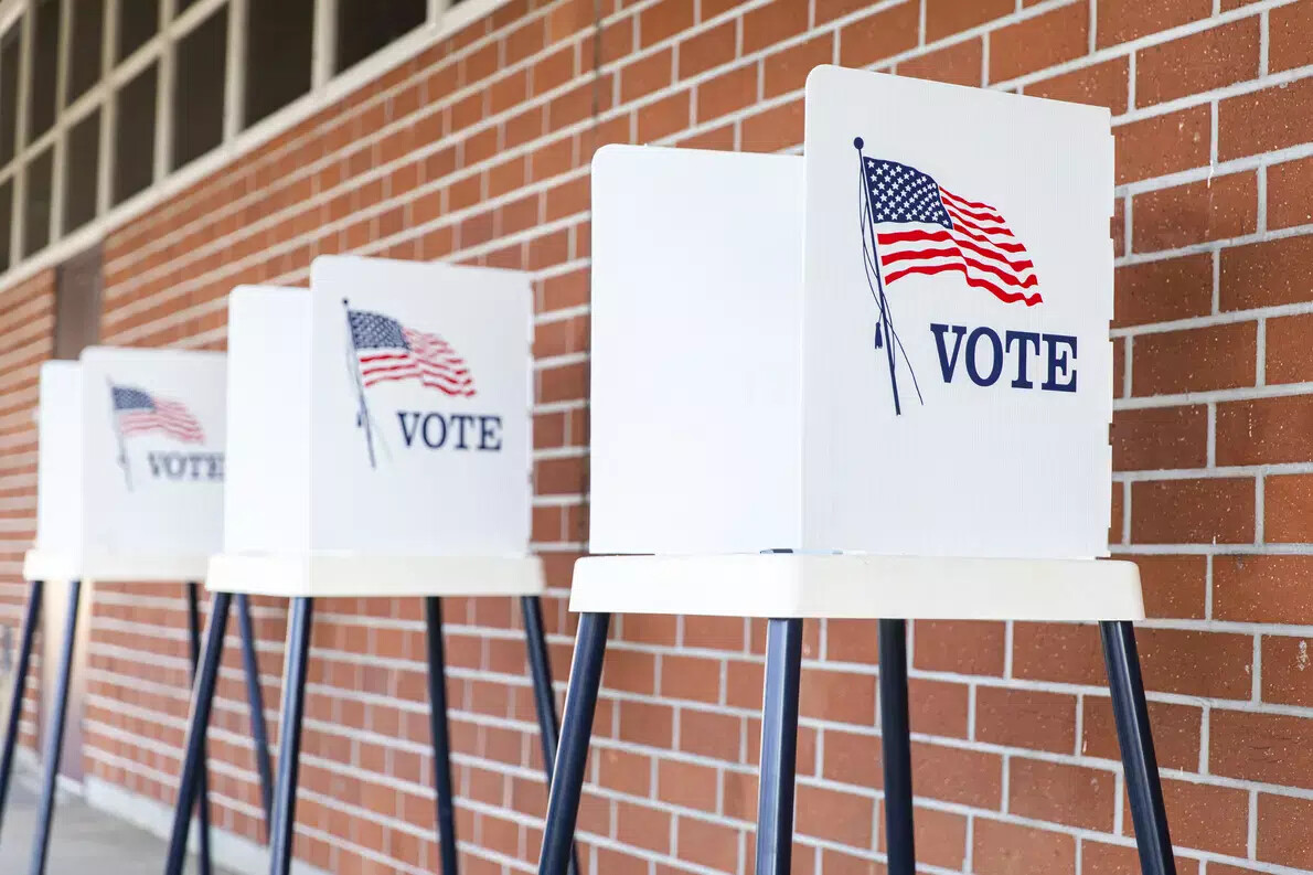 voting signs against brick wall