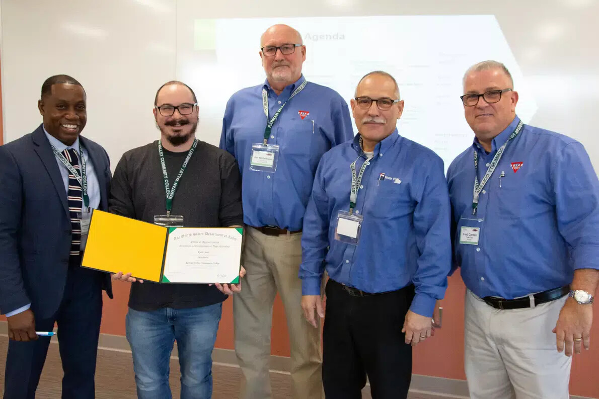 five men with one holding certificate