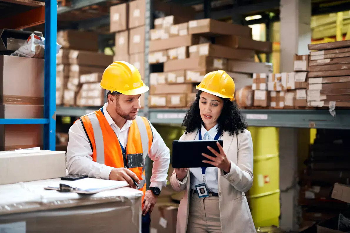 woman and man in yellow hardhats in warehouse