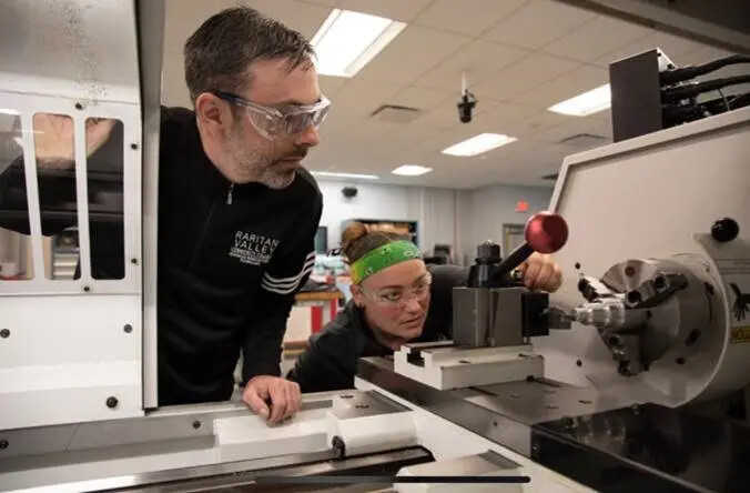 advanced manufacutring instructor and female student in green headband