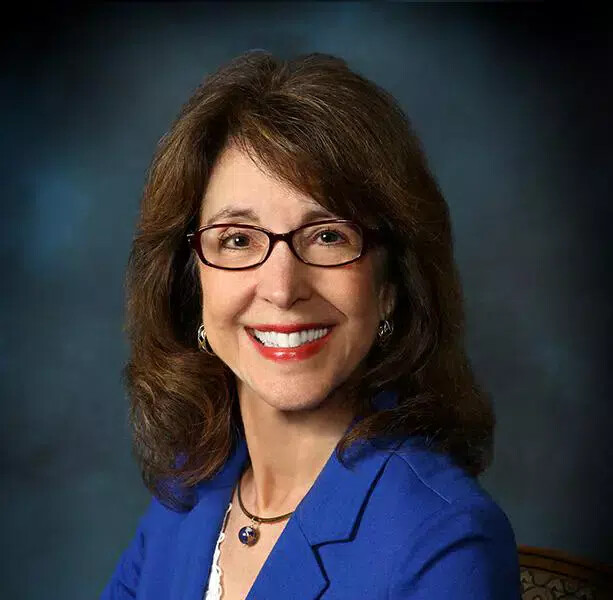 ellen kennedy in blue jacket and glasses