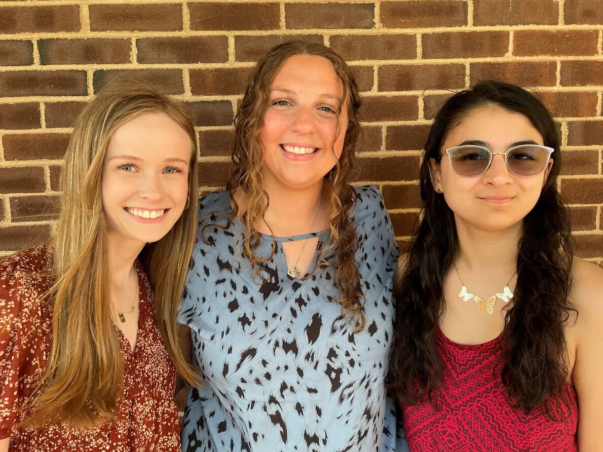 3 females against brick wall