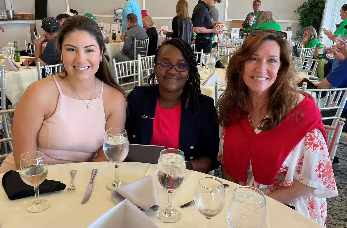 2 female nursing students and female faculty at table with glasses