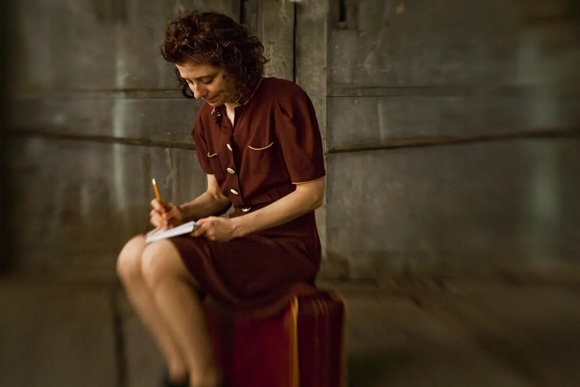 woman sitting in chair and writing