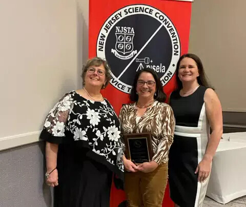 amie gallagher holding award and 2 other women with her