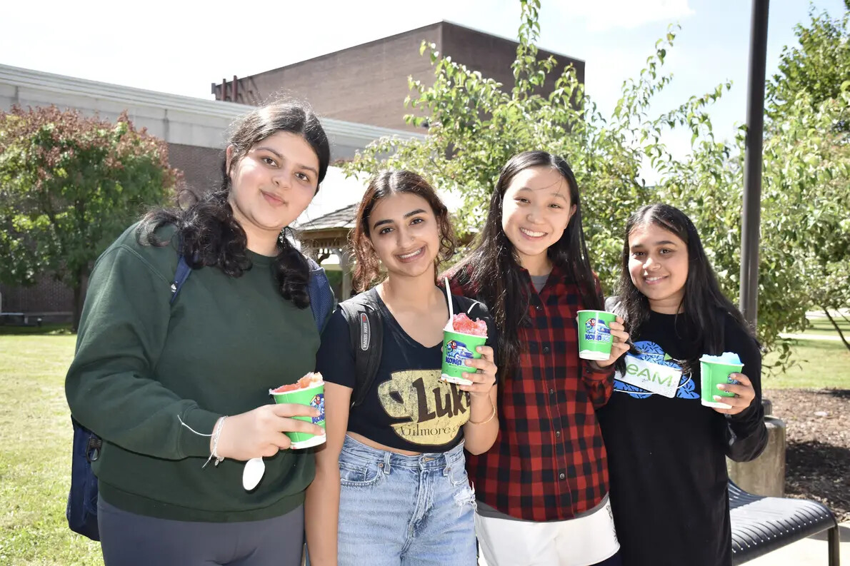 four female students outsdie holding up cups