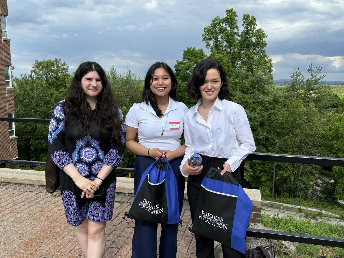 three female students outside and two with drawstring bags