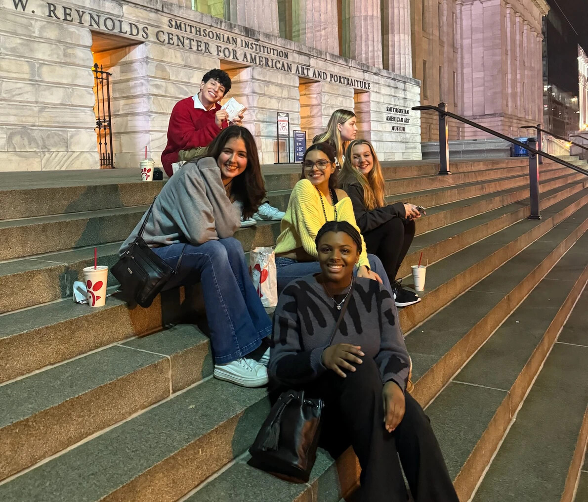 students sitting on steps outside