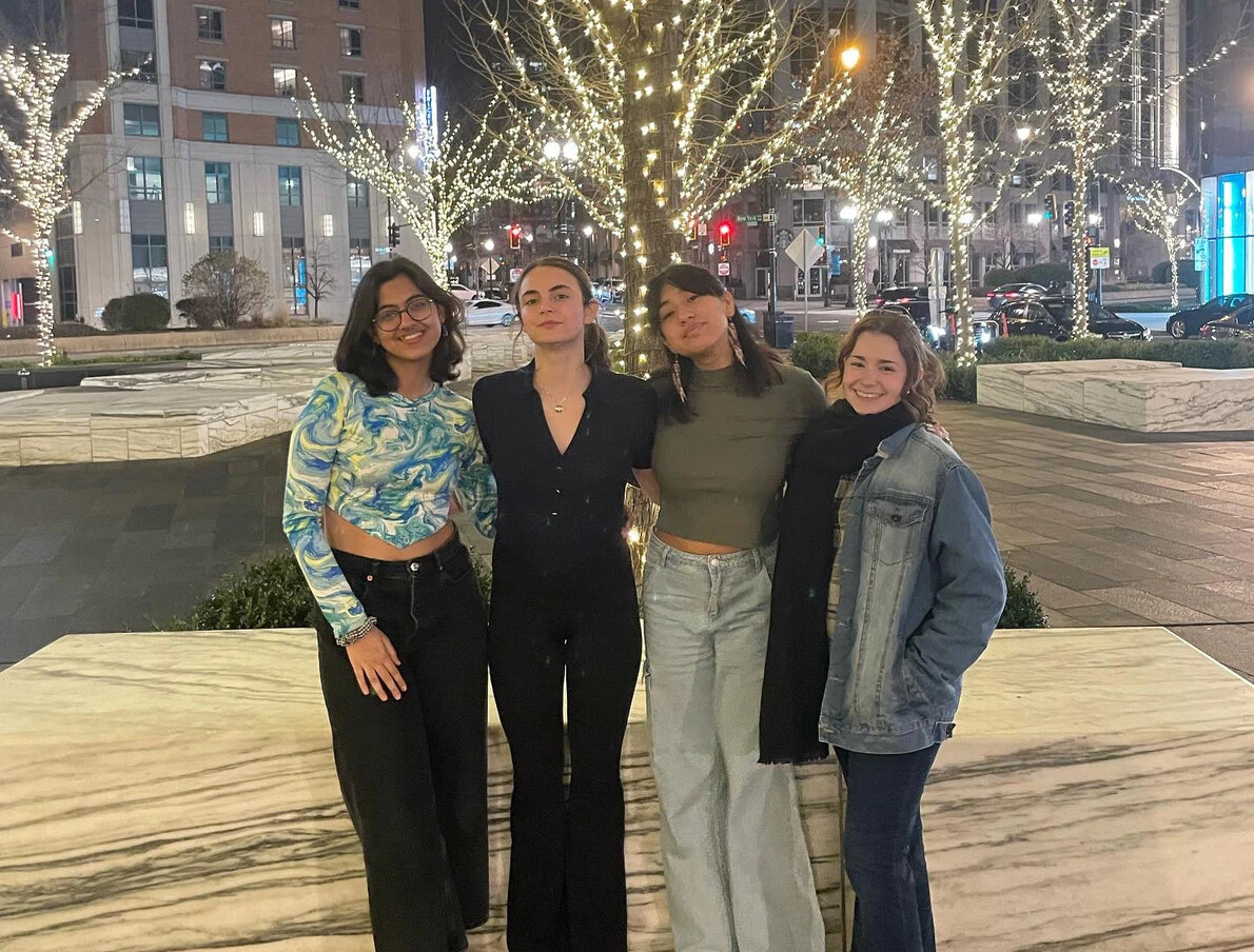 4 female students with holiday lights