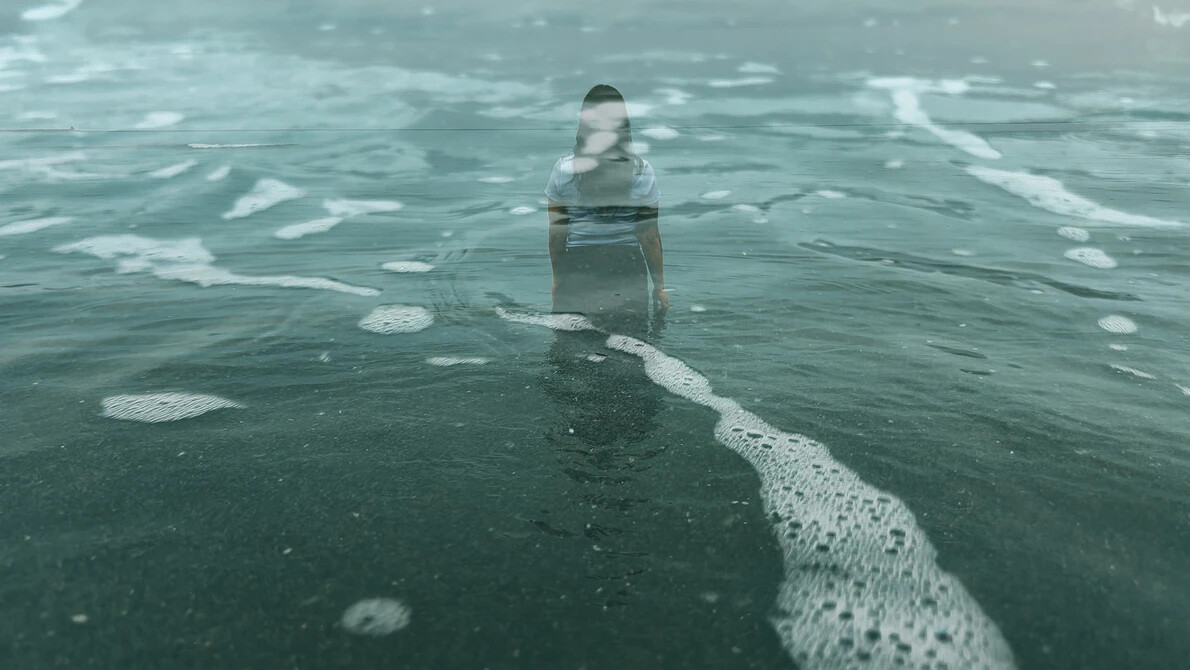 art photograph of woman walking into water