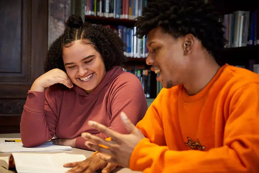 2 fisher college students, one with orange shirt