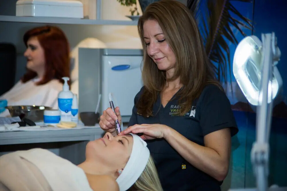 cosmetology student giving facial treatment