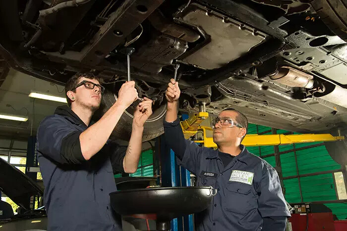 students working under car