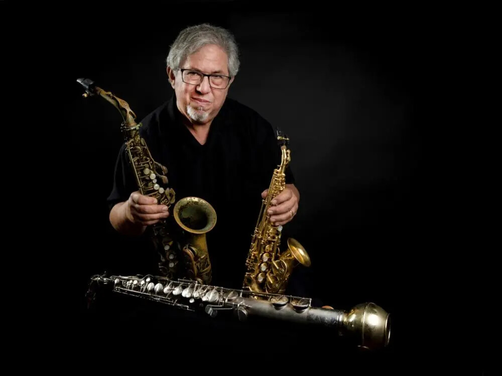 saxophone player paul cohen holding instruments