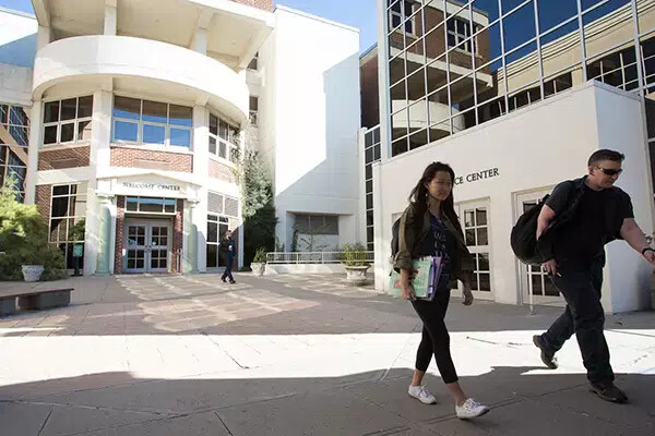 two students walking in front of college