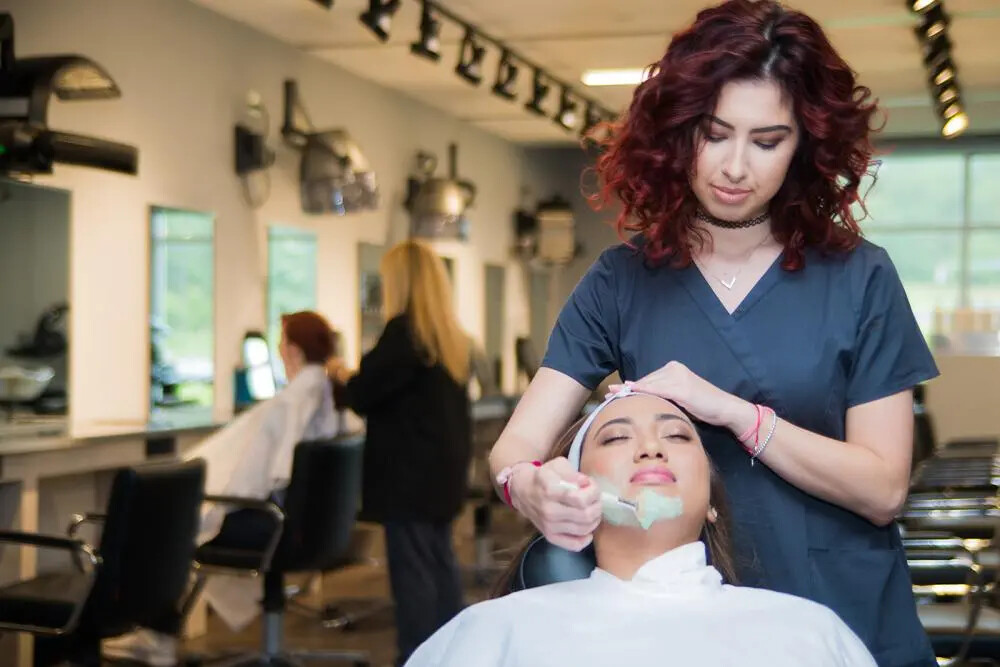 cosmetology lab with one student working on another student's skin