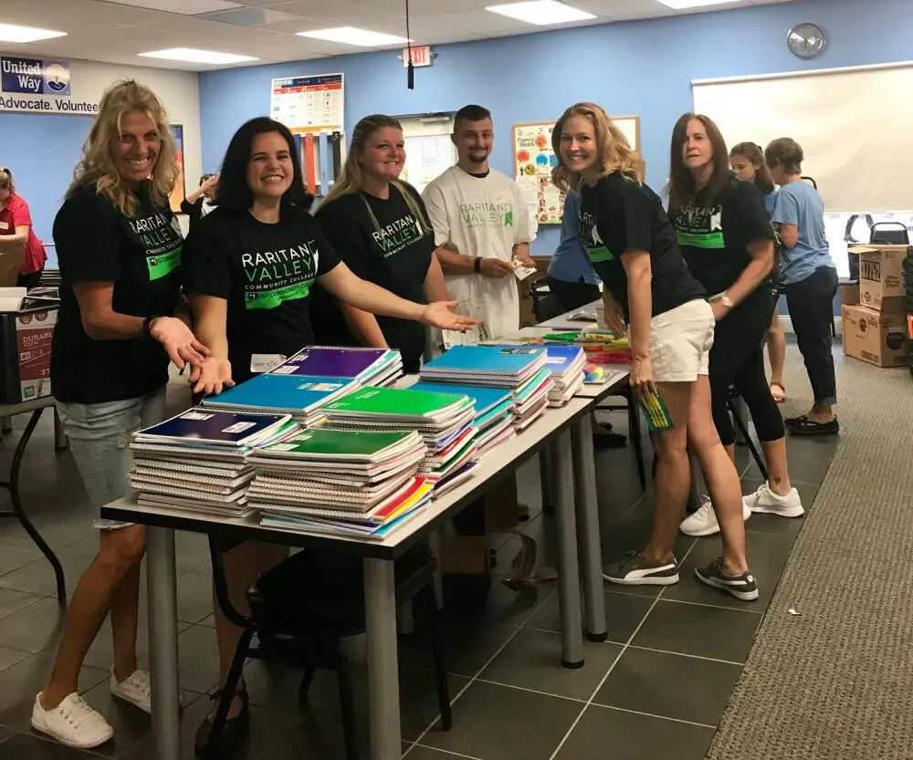 students around table of collected school supplies