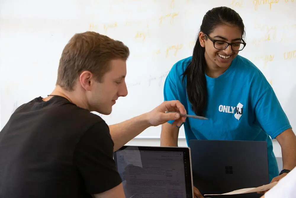 male and female students at laptops