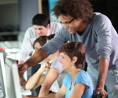 teacher helping student at computer