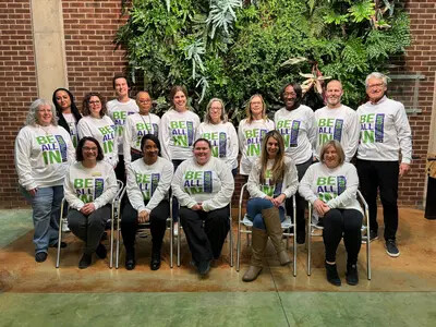 staff pic on Giving Day 2024 in front of green wall