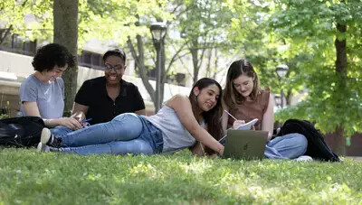 four female students sitting or lying on ground