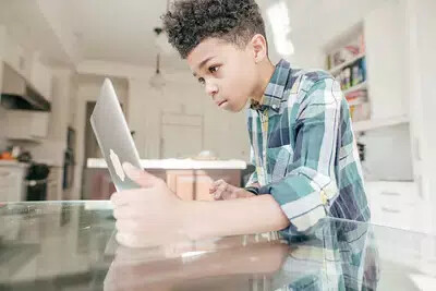 boy in plaid shirt on laptop