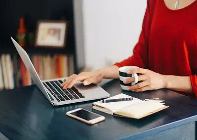 woman in red sweater on laptop