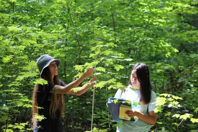 2 female students working outside on environmental project