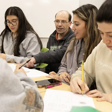 male professor and three students in class